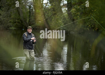 Un homme pêche à la mouche dans une rivière - Londres, Royaume-Uni Banque D'Images