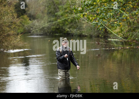 Un homme pêche à la mouche dans une rivière - Londres, Royaume-Uni Banque D'Images