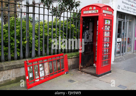 Téléphone rouge traditionnel cassé call box. Londres, Royaume-Uni. Rarement utilisé de nos jours, ces vieilles boîtes téléphone rouge sont souvent dans un état très délabré. Ou utilisé pour des utilisations peu recommandables. Banque D'Images