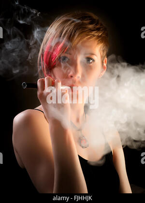 Femme élégante avec l'excentrique hairstyle fumeurs fumée avec e-cigarette Banque D'Images