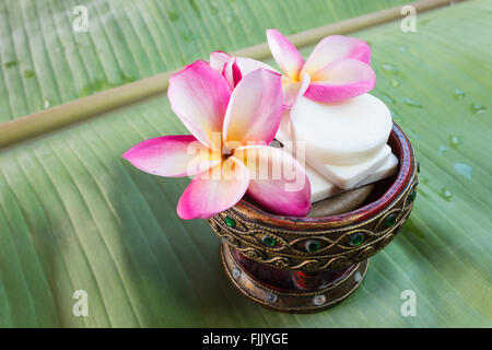 Mini jeu de douche savon avec des fleurs de frangipaniers sur des feuilles de banane verte Banque D'Images