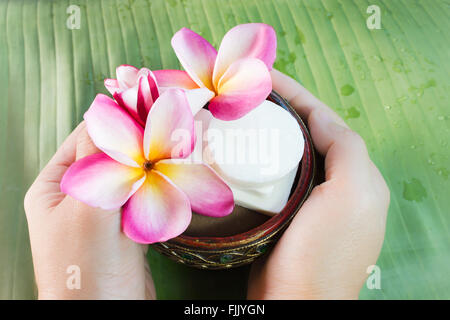 Prendre la main mini série de savon de bain de fleurs de frangipaniers sur vert feuille de bananier with copy space Banque D'Images