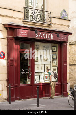 L'homme à la recherche de gravures anciennes en vitrine sur la rue du Dragon dans le quartier branché quartier Saint Germain, Paris, France Banque D'Images