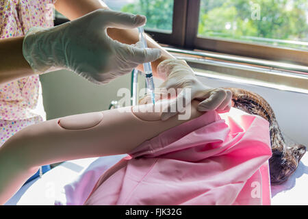 Une photo du docteur démontre comment une injection au patient modèle. Banque D'Images