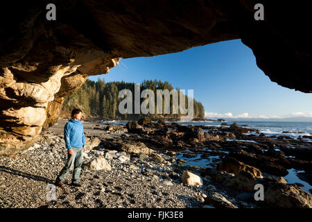 Randonneur dans une caverne sur Sombrio Beach - parc provincial Juan de Fuca, l'île de Vancouver, Colombie-Britannique, Canada Banque D'Images