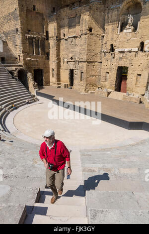 Solo homme d'âge moyen, avec un appareil de tourisme explorer les ruines du théâtre romain d'Orange, Provence, France Banque D'Images