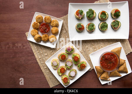 Une variété de tapas en bonne santé y compris l'avocat toast, samosas et concombre hoummos morsures. Banque D'Images