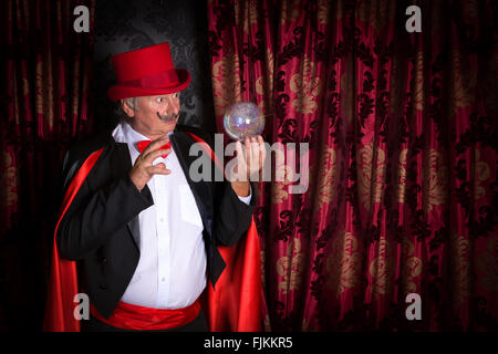 Magicien principal sur scène avec une boule de cristal Banque D'Images