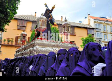 Un groupe de porteurs à capuchon (appelés Costaleros) portant un flotteur religieux (appelé Tronos) dans les processions tenue à Malaga Banque D'Images