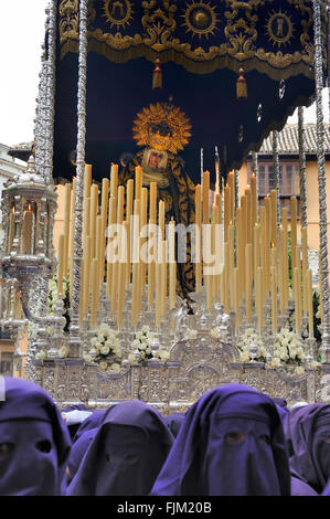 Un groupe de porteurs à capuchon (appelés Costaleros) portant un flotteur religieux (appelé Tronos) dans les processions tenue à Malaga Banque D'Images