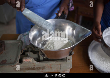 Une femme pesant baker farine pour faire des gâteaux, Tanzanie Banque D'Images