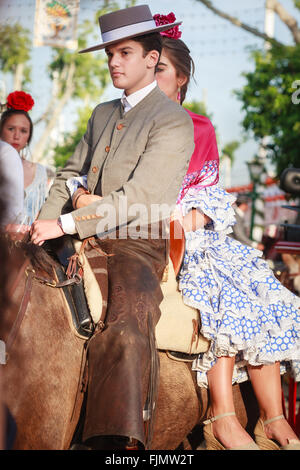 Séville, Espagne - 23 Avril 2015 : Couple en costume traditionnel à cheval au la foire d'Avril de Séville. Banque D'Images