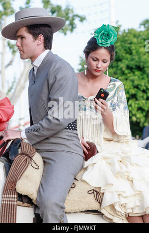 Séville, Espagne - 28 Avril 2015 : Couple en costume traditionnel à cheval au la foire d'Avril de Séville. Banque D'Images
