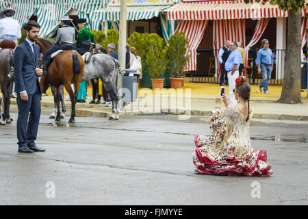 Séville, Espagne - 29 avril, 2015:Les jeunes femmes portant robe flamenco traditionnel de prendre une photo à la foire d'Avril de Séville. Banque D'Images