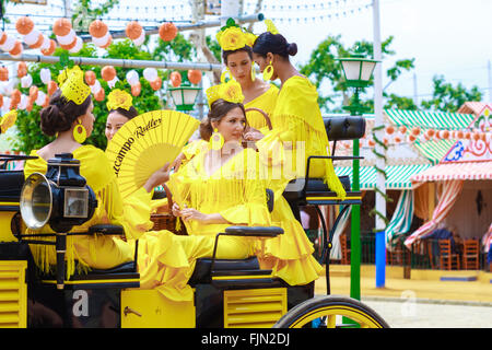 Séville, Espagne - 29 Avril 2015 : les jeunes et belles femmes sur une calèche au cours de la la foire d'Avril de Séville. Banque D'Images