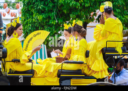 Séville, Espagne - 29 Avril 2015 : les jeunes et belles femmes sur une calèche au cours de la la foire d'Avril de Séville. Banque D'Images