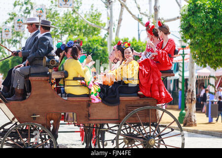 Séville, Espagne - 28 Avril 2015 : les jeunes et belles femmes sur une calèche au cours de la la foire d'Avril de Séville. Banque D'Images