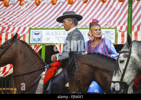 Séville, Espagne - 28 Avril 2015 : Couple en costume traditionnel à cheval au la foire d'Avril de Séville. Banque D'Images
