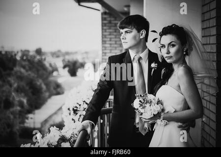 Photographie noir et blanc beau jeune couple debout sur le balcon Banque D'Images