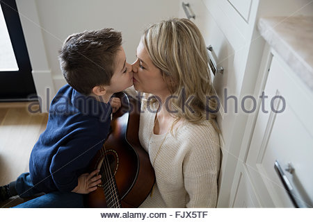 Mère embrassant son fils avec guitare