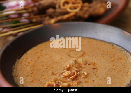 Pour la sauce aux arachides sate Blora, poulet satay de Blora région dans le centre de Java. Servi sur de la vaisselle en terre cuite traditionnels. Banque D'Images