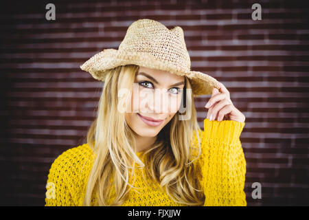 Belle blonde woman holding her hat Banque D'Images