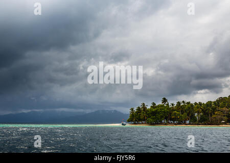 Nuages de tempête de la fermeture sur l'île tropicale de la voile et de palmiers dans des vents de flexion Banque D'Images