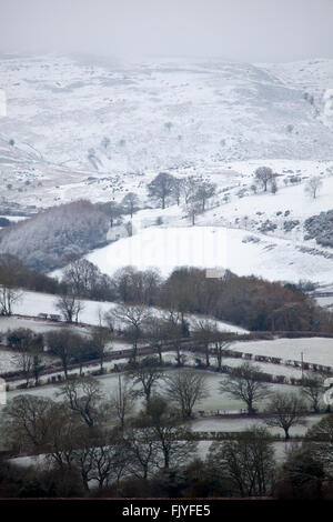 Les terres agricoles et les collines ou Clwydian range dans la distance parcourue dans la neige la nuit au début du printemps. Une vue de l'ensemble de Lixwm Nannerch vers l'Clwydian Hills Banque D'Images