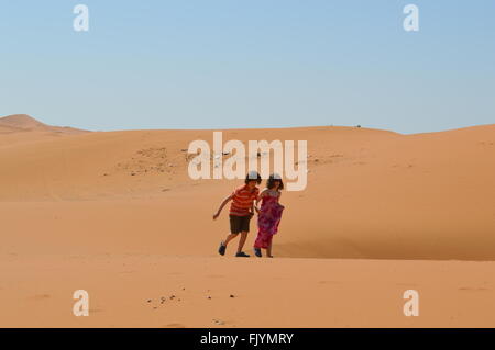 Enfants courir dans les dunes de sable dans le Sahara Banque D'Images