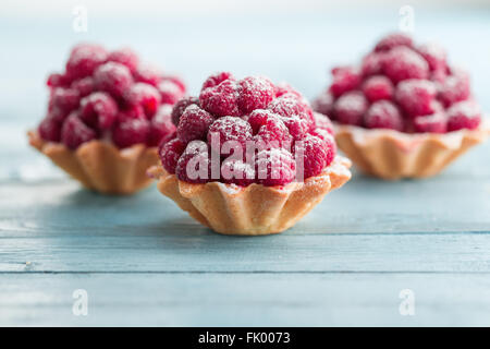 Tartelettes aux framboises avec la crème et saupoudrés de sucre glace Banque D'Images