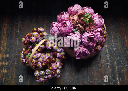 Deux panier plein de pivoines rose et violet , bourgogne , panier avec poignée est sur le plancher en bois, vue du dessus Banque D'Images