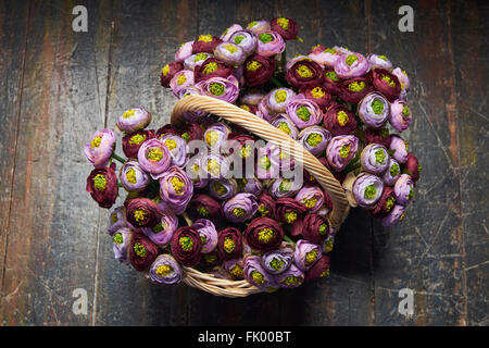 Panier plein de pivoines rose et violet , bourgogne , panier avec poignée est sur le plancher en bois, vue du dessus Banque D'Images