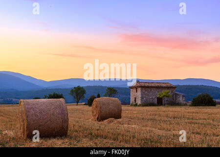 Coucher de soleil sur champ agricole avec des balles de foin près de Sault, Provence-France Banque D'Images