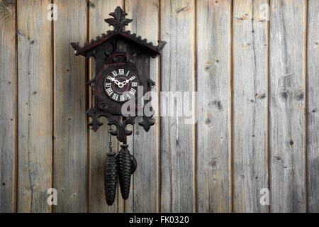 Vieille horloge coucou de la Forêt Noire, sur un mur en bois, Allemagne Banque D'Images