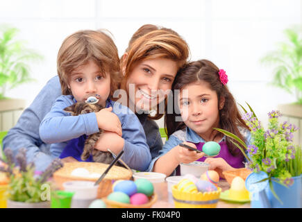 Portrait de famille heureuse la préparation à Pâques, mère de deux enfants mignons, les oeufs de Pâques la teinture traditionnelle symbole Banque D'Images