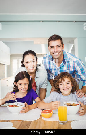 Cheerful man et woman with children having breakfast Banque D'Images