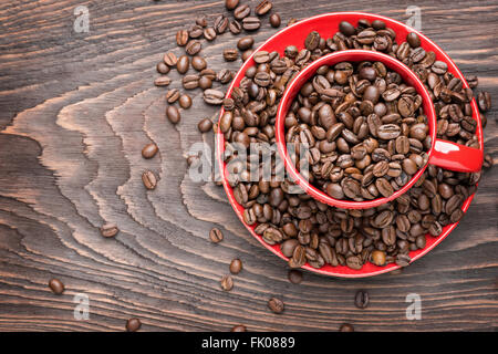 Tasse rouge rempli de grains de café sur fond de bois, télévision lay Banque D'Images