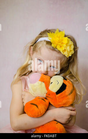 Belle jeune fille avec de longs cheveux blonds holding plush toy Banque D'Images