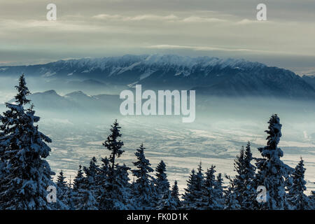 Paysage hivernal de coucher de soleil sur les montagnes Piatra Craiului à Brasov, Roumanie. Banque D'Images