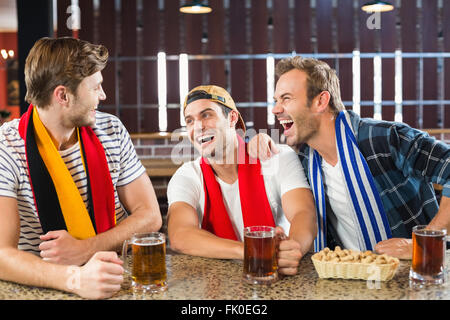 Les hommes de rire avec bières dans les mains Banque D'Images