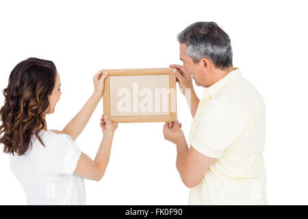 Heureux couple holding photo frame Banque D'Images