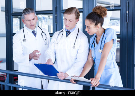 Rapport médical Doctors discussing in corridor Banque D'Images