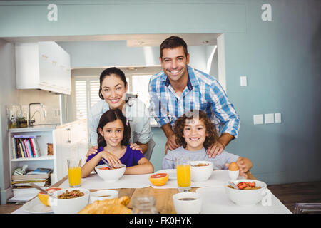 Heureux l'homme et de la femme avec des enfants ayant le petit déjeuner Banque D'Images