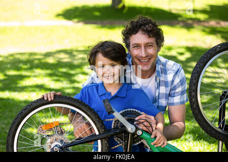 Père et fils fixant le vélo Banque D'Images