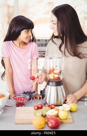 Mère et fille joyeuse préparation de jus de fruits Banque D'Images