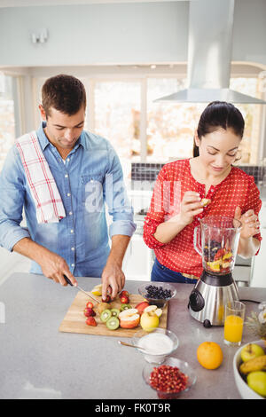 Couple en train de préparer des jus de fruits Banque D'Images