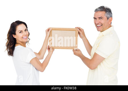 Heureux couple holding photo frame Banque D'Images