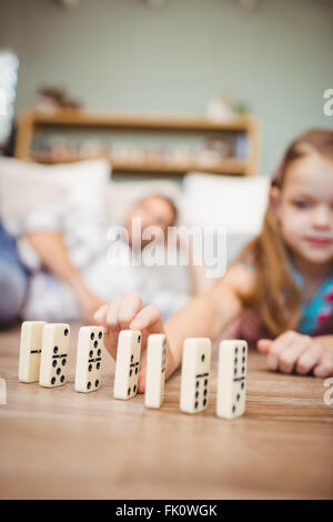 Organiser fille domino sur plancher de bois franc à la maison Banque D'Images