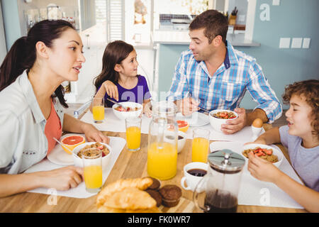 Famille heureuse de parler tout en ayant le petit déjeuner Banque D'Images