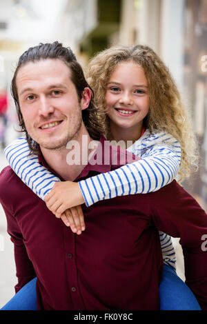 Father giving daughter un piggyback ride Banque D'Images